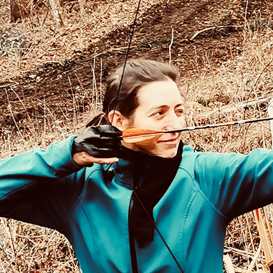 Claudia beim Bogenschießen bei einem Teamevent.